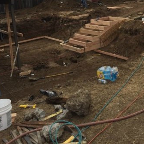 A landscaping construction site with a dirt mound