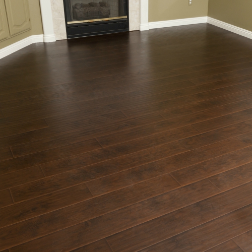A room with a dark wood floor and a fireplace