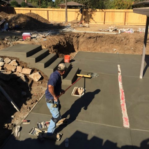A construction site with a dirt mound, wooden steps being built