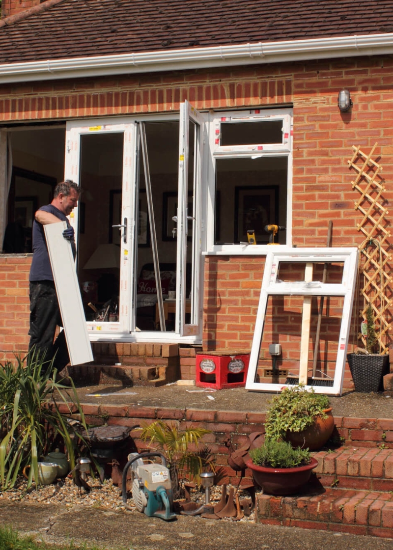 Construction worker carefully measuring and installing a window frame
