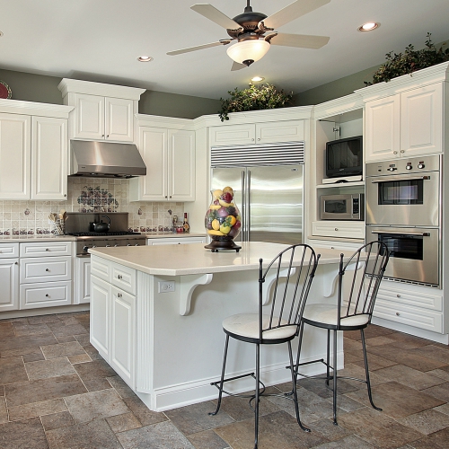 A spacious kitchen with white cabinets and a large island
