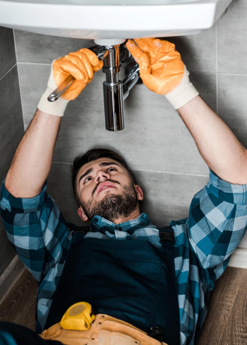 Close-up of a plumber's hands working on a plumbing system